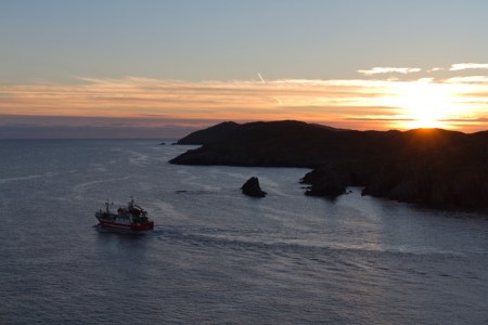 fishing-boat-leaving-sherkin-island-baltimore-harbour-mouth-at-sunset-from-beacon-5810