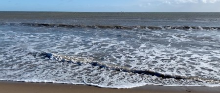 Photo of waves lapping on the sand.